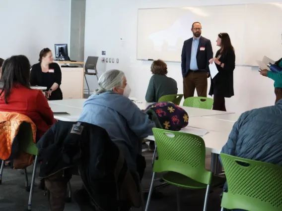 Two individuals moderate a group discussion. 